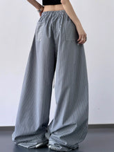 Gray and white striped wide leg drawstring pants with elastic waistband and patch pockets for casual wear