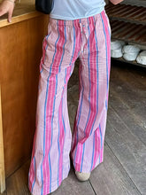 Striped wide leg drawstring pants with pink blue and white vertical stripes and an elastic waistband