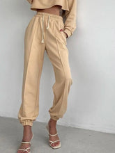 Beige casual drawstring jogger pants and cropped sweatshirt with cuffed ankles for comfortable everyday wear