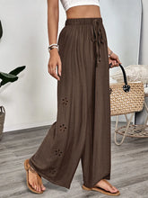 Brown casual wide-leg pants with a drawstring waist and floral cut-out details, featuring care instructions