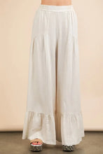 Cream-colored palazzo pants with soft flowing fabric and delicate ruffled hems featuring a palazzo elastic waist comfy fit
