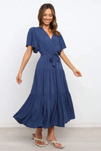 Navy blue tiered wrap dress with flutter sleeves and tie waist