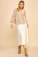 Beige chunky knit cardigan with lace-up ribbon bow, white skirt, brown boots