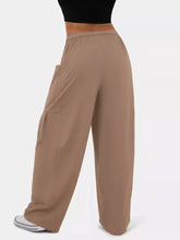 Beige drawstring wide leg pants with relaxed fit and side pockets featuring a wide leg cargo style design