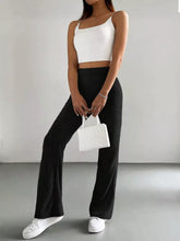 White structured mini handbag with top handles paired with high waist flare pants for a stylish look