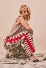 The model is wearing biBi leopard print pants with wide-leg silhouette and red vertical stripes print pants