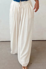 White tie waist pleated wide leg pants with flowing soft fabric and adjustable drawstring waist for comfort and style