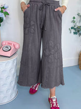 Gray terry knit wide leg pants with flower patch mineral washed fabric and embroidered floral patches with drawstring waist