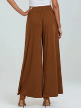 High-waisted brown wide leg pants with elastic waistband flowing lightweight fabric and functional pockets