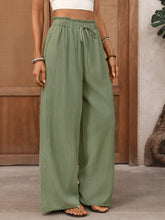 Olive green wide leg drawstring waist pants with subtle vertical ribbing for comfortable casual wear