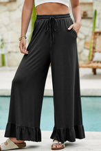 Black ruffled wide leg pull on high waist pants with drawstring waist and pockets for comfortable wear
