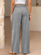 Black and white gingham high waist wide leg pants featuring a high waistband and flowy wide leg design