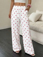 White wide-leg pants with heart print drawstring waist and ribbed texture featuring red heart pattern