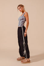 Black loose fit jogger pants with white double lined side stripes and tied ends designed for comfortable wear