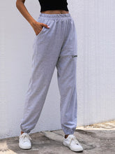 Light gray heathered casual high waist cutout joggers with elastic waistband, drawstring, side pockets, and zippered cargo pocket