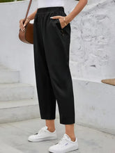 Black high rise cropped trousers with elastic waist and side pockets made from comfortable fabric