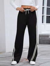 Black striped wide leg pants with white side stripes and matching drawstring waistband for casual wear