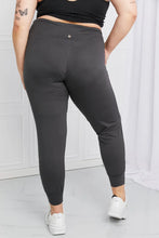 Dark gray pocketed high-waist pants with snug fit and elastic cuffs paired with ankle boots from leggings depot
