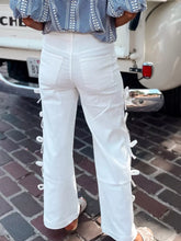 White lace-up wide-leg pants with bow accents and subtle stitching details for a perfect fit and clean silhouette