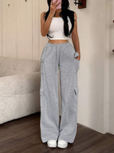 Gray cargo pants with a relaxed fit and multiple side pockets featuring a casual drawstring loose fit design