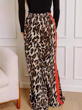 Leopard print wide leg pants featuring a vibrant orange side stripe for a bold and stylish look