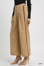 Umgee tan pleated wide-leg pants with contrast trim featuring a bold leopard print stripe down the outer seam