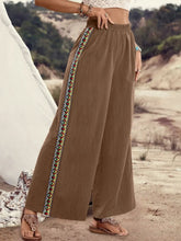 Brown bohemian wide leg pants with colorful embroidered side stripe suitable for care instructions label