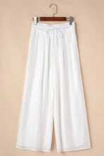 White flowing tie waist pleated wide leg pants with drawstring waistband for a comfortable stylish fit