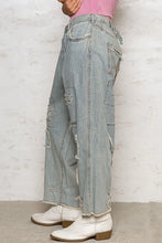 Light-wash denim distressed raw hem wide leg pants with vertical pinstripes and ripped details along the legs