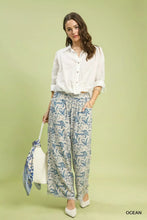 White linen blend wide leg pants with blue leaf printed raw hem and elastic waistband by umgee linen printed wide