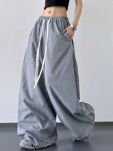 Gray and white striped wide leg drawstring pants with elastic waistband and decorative tie for comfortable wear