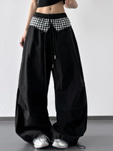 Black wide leg pants featuring a contrasting black and white checkered waistband with drawstring detailing