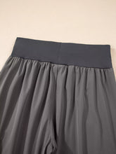 Gray elastic high waist pocketed cargo jogger pants made of lightweight flowing fabric with stretchy waistband