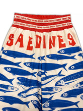 Plus size printed wide leg cream shorts with bold blue fish print red lettering and matching red elastic waistband