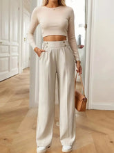 Cream-colored full size high-waisted wide-leg pants with tailored fit and subtle pleats, machine wash cold