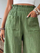 Green textured fabric high-waisted wide leg pants with elastic waistband and front pockets for comfortable wear