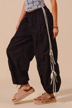 Black loose fit jogger pants with white striped double lined side panels and tassels for comfortable casual wear