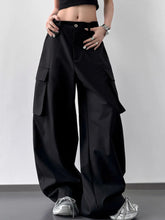 Black wide leg cargo pants featuring large side pockets and button closure in durable fabric for versatile wear