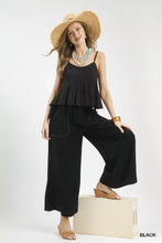 Black ruffled camisole top paired with linen frayed side pocket wide leg pants showcasing wide leg pants style