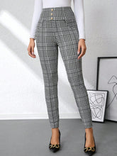 High waist plaid slim fit pants in black and white houndstooth pattern with button closure at the waist