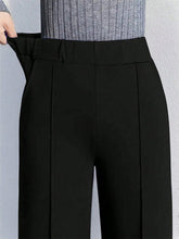 Black high-waisted wide leg pants with tailored pleated design and elastic waistband for comfortable wear