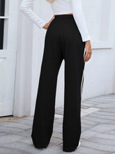 Black striped wide leg pants featuring a side stripe detail in a comfortable wide leg fit