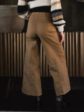 Tan high-waisted wide leg cropped pants made of polyester fabric with visible side pockets for stylish comfort