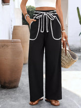 Black wide-leg trousers with white crochet trim and a matching tie waist drawstring for comfortable styling