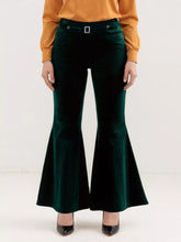 Plus size emerald green velvet flared pants with a silver-toned rectangular buckle at the waist