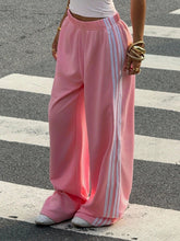 Pink wide leg track pants with three white stripes down the side perfect for casual wear and comfort