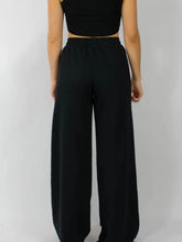 Black high-waisted wide leg pants made of soft flowing fabric with an elastic waist wide design for comfort