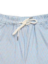 Light blue and white drawstring striped wide leg swim trunks with cream-colored drawstring and vertical stripes