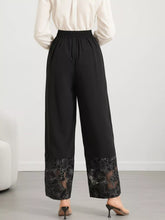 Black wide leg trousers with intricate floral lace hem detailing at cuffs featuring lace hem wide design