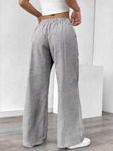 Striped wide leg pants with vertical gray and white stripes featuring an elastic waistband for comfort